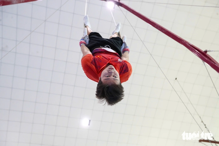 Khánh Phong đang thực hiện động tác treo ngược cơ thể, một phần trong giáo án tập luyện của anh.