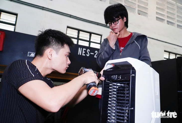 Các bạn sinh viên tham gia sửa chữa thiết bị hư hỏng do mưa lũ - Ảnh: TRẦN HOÀI

