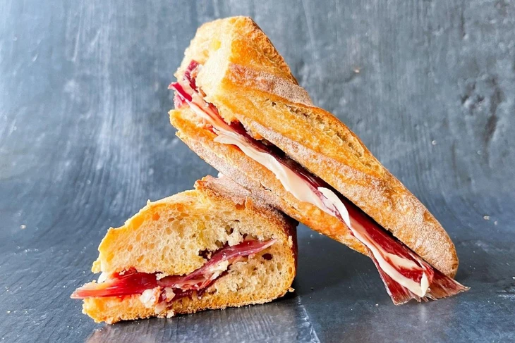 Ở Tây Ban Nha, Bocadillo de jamón Ibérico gây ấn tượng với thịt giăm bông Iberia thượng hạng, thái mỏng và xếp trên bánh mì giòn, đôi khi thêm cà chua và phô mai, tạo nên món ăn vừa đơn giản vừa tinh tế - Ảnh: Bon Viveur