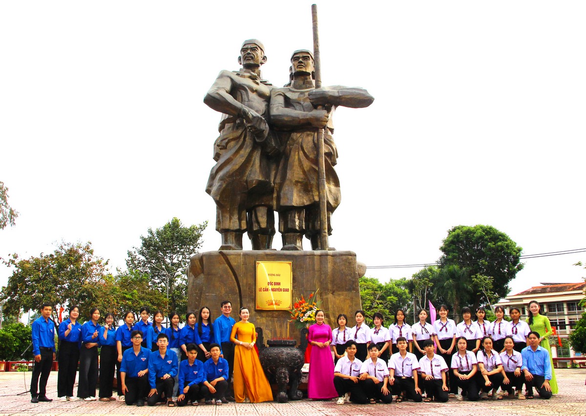 Đại biểu và các em học sinh, sinh viên thắp hương và chụp ảnh lưu niệm tại tượng đài Lê Cẩn - Nguyễn Giao, Bia Nam Kỳ Khởi nghĩa.