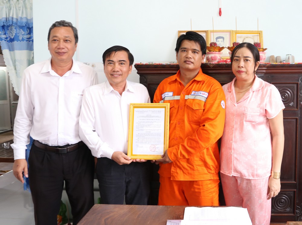 Ông Bùi Thanh Hùng- Chủ tịch Công đoàn cơ sở Công ty Điện lực Vĩnh Long (thứ 2 bên trái qua) trao quyết định hỗ trợ nhà cho đoàn viên Hồ Hải.

