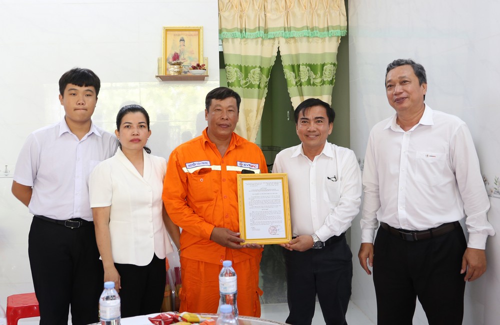 Ông Bùi Thanh Hùng- Chủ tịch Công đoàn cơ sở Công ty Điện lực Vĩnh Long (thứ 2 bên phải qua) trao quyết định hỗ trợ nhà cho đoàn viên Nguyễn Văn Phong.


