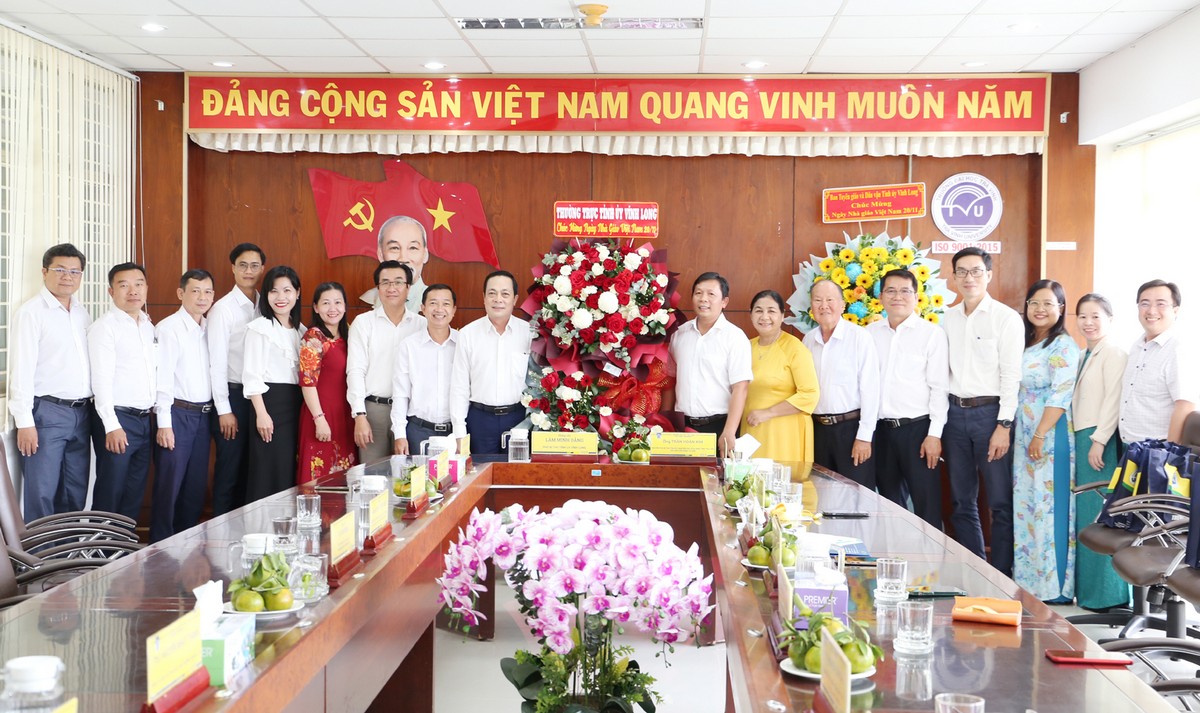Phó Bí thư Tỉnh ủy- Lâm Minh Đằng tặng hoa chúc mừng và chụp ảnh lưu niệm cùng Ban giám hiệu, giảng viên Trường Đại học Trà Vinh.

