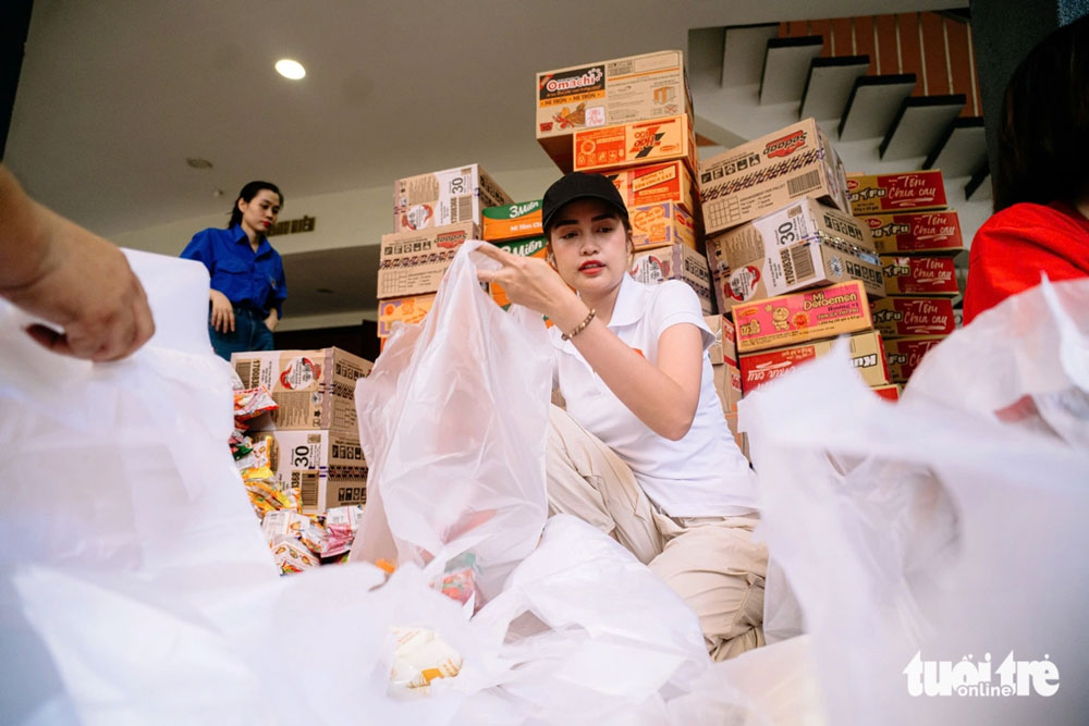 Hoa hậu Hoàn vũ Việt Nam 2022 Nguyễn Thị Ngọc Châu cùng các thành viên Đội tình nguyện viên nghệ sĩ TP.HCM tất bật sắp xếp từng phần quà cứu trợ - Ảnh: THANH HIỆP