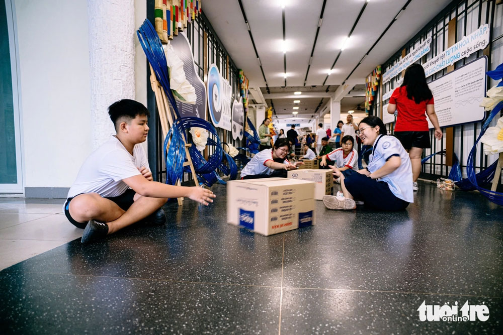 Không ngại mệt nhọc, từng bạn trẻ ngồi bệt xuống sàn, tay thoăn thoắt chuyền từng thùng nhu yếu phẩm - Ảnh: THANH HIỆP