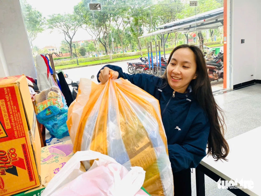 Chị Lê Thị Tường Vy (29 tuổi) tranh thủ mang mấy thùng mì và nước đến điểm tiếp nhận. Vừa nghe có điểm gom hàng Vy lập tức báo bạn bè. Ai bận không mang đến được, chị nhận đem gửi giúp - Ảnh: CHÂU SA