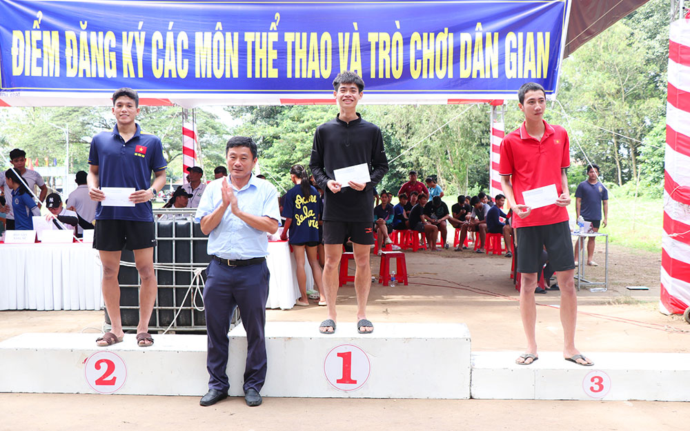 Ban tổ chức trao giải cho các vận động viên đoạt giải môn nhảy bao bố nam.