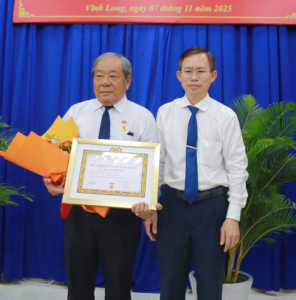 Trưởng Ban Tổ chức Tỉnh ủy- Nguyễn Văn Hiếu trao Huy hiệu 45 năm tuổi Đảng cho đảng viên. Ảnh: NGUYỄN THỊNH