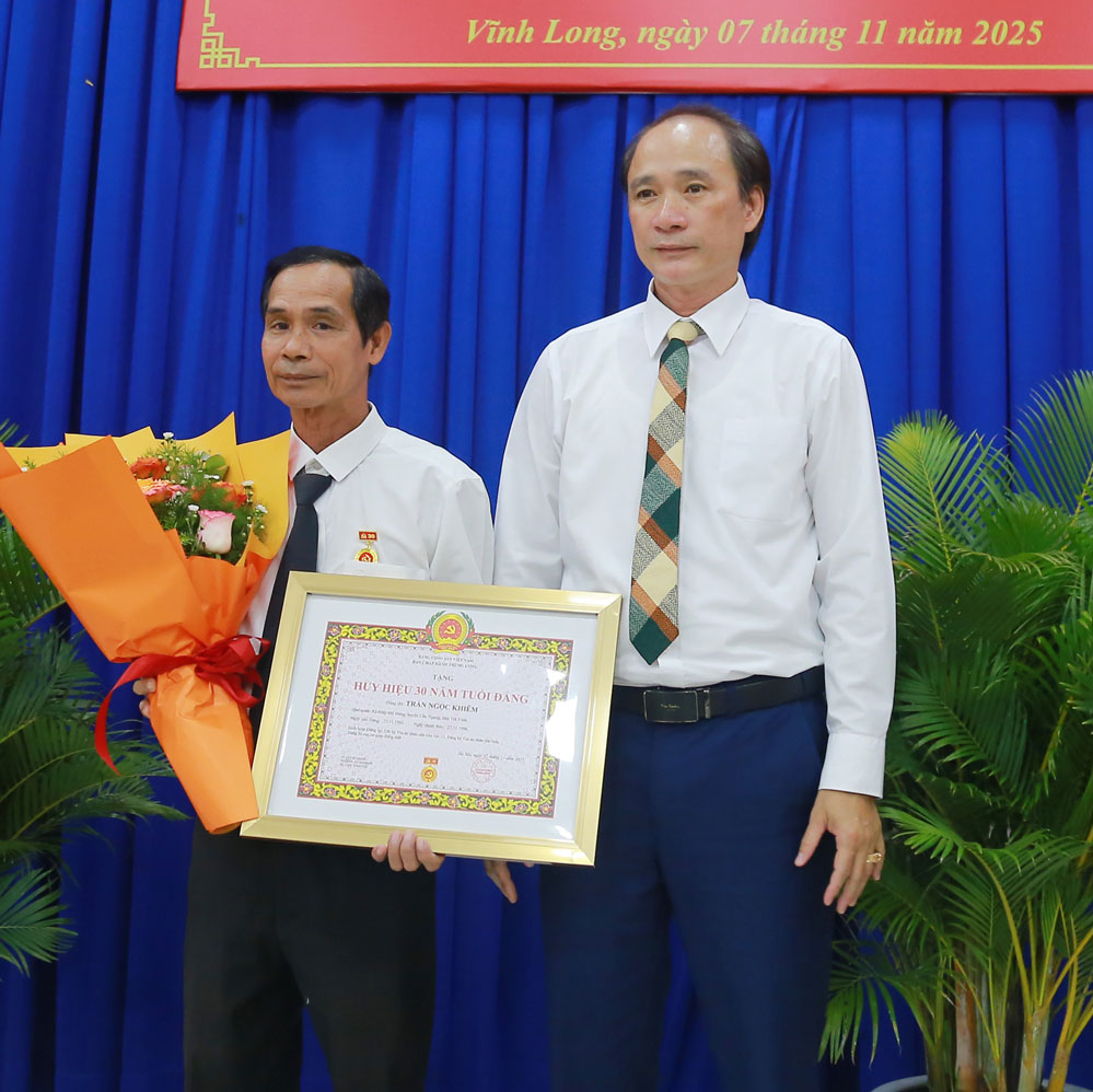 Phó Bí thư Đảng ủy Các cơ quan Đảng tỉnh- Trần Xuân Thiện trao Huy hiệu 30 năm tuổi Đảng. Ảnh: NGUYỄN THỊNH
