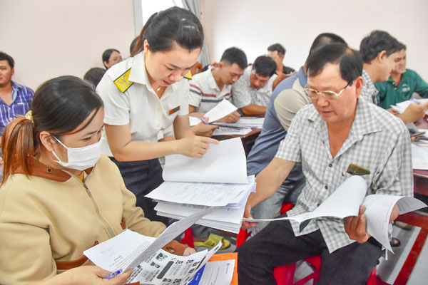 Công chức Nguyễn Thị Hồng Dân (Thuế cơ sở 5) hướng dẫn thủ tục chuyển đổi thuế cho hộ kinh doanh xã Châu Thành.

