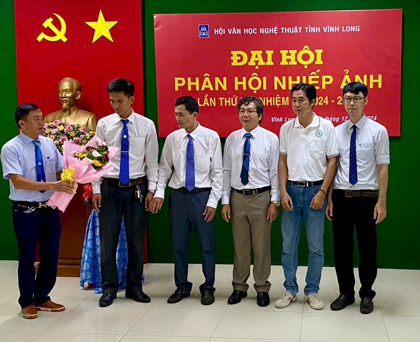 Nghệ sĩ Nhiếp ảnh Nguyễn Vinh Hiển- Chi hội trưởng Chi hội NSNA tỉnh Vĩnh Long tặng hoa cho BCH mới.