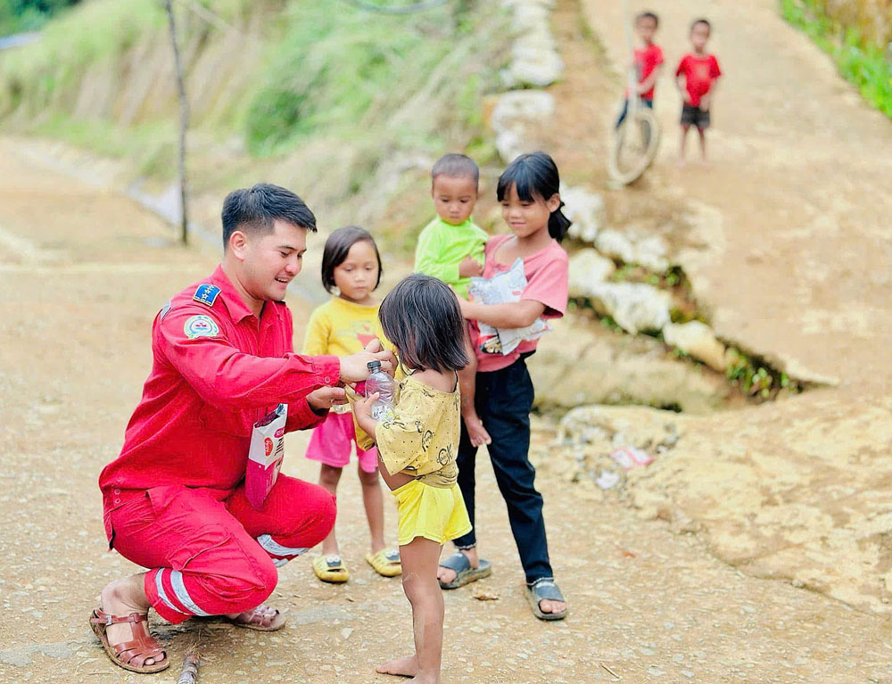 Anh Trần Huỳnh Hoài Phong- Đội trưởng Đội Tìm kiếm cứu nạn, cứu hộ và Trợ giúp nhân đạo tặng quà cho trẻ em vùng núi. Ảnh do nhân vật cung cấp

