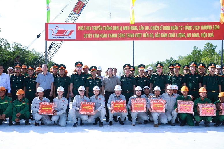 Thủ tướng Phạm Minh Chính tặng quà công nhân thi công tại điểm đầu xây dựng tuyến giao thông ra đảo Hòn Khoai - Ảnh: TTXVN