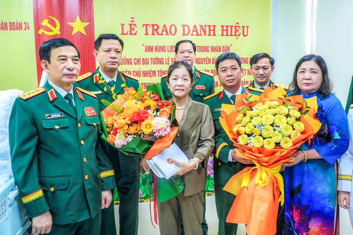 Đại tướng Phan Văn Giang cùng Phó Bí thư Thường trực Tỉnh ủy- Hồ Thị Hoàng Yến tặng hoa chúc mừng gia đình Đại tướng Lê Văn Dũng. Ảnh: THANH PHONG

