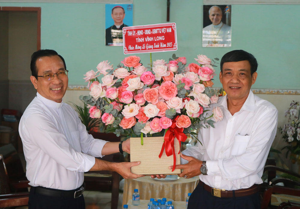 Phó Chủ tịch Ủy ban MTTQ Việt Nam tỉnh Kiên Banh tặng hoa chúc mừng Nhà thờ Chánh tòa và Linh mục Nguyễn Ngọc Tân (phường Long Châu). Ảnh: TUYẾT NGA.