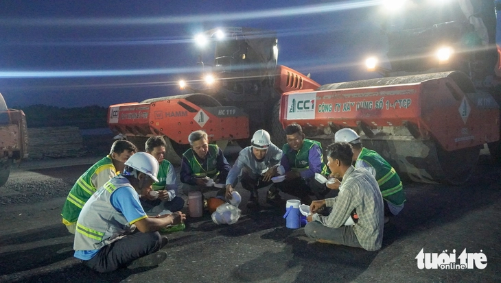 Nhiều công nhân tranh thủ thời gian ăn cơm tại công trường, rồi tiếp tục làm việc - Ảnh: THANH HUYỀN

