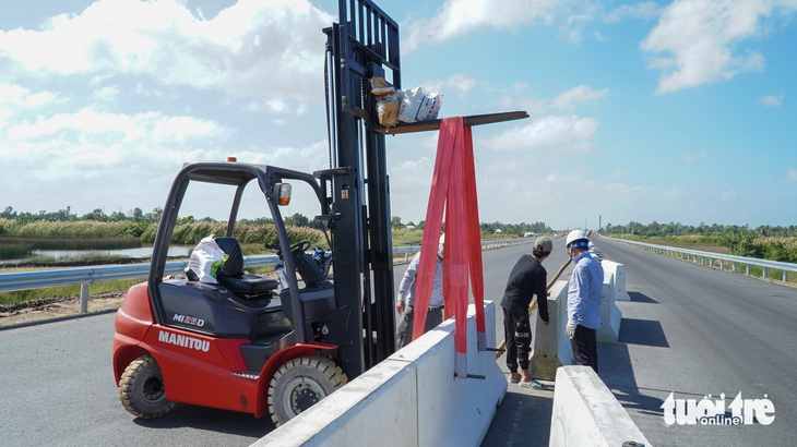 Lắp dải phân cách, hoàn thiện những bước cuối để kịp thông xe kỹ thuật - Ảnh: THANH HUYỀN

