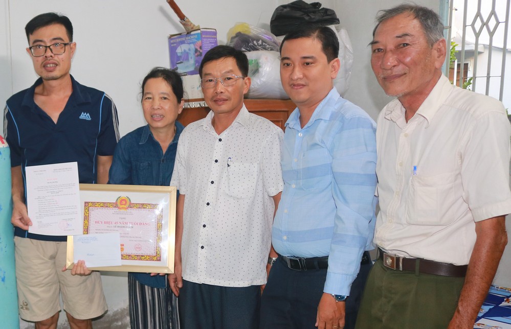 Đại diện gia đình đảng viên Lê Hoàng Cách nhận Huy hiệu Đảng.