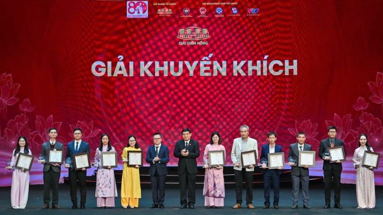 Đồng chí Lê Quốc Minh, Ủy viên Trung ương Đảng, Phó Trưởng Ban Tuyên giáo và Dân vận Trung ương, Tổng Biên tập Báo Nhân Dân, Chủ tịch Hội Nhà báo Việt Nam, Chủ tịch Hội đồng Chung khảo Giải Diên Hồng lần thứ tư và đồng chí Nguyễn Đắc Vinh, Ủy viên Trung ương Đảng, Chủ nhiệm Ủy ban Văn hóa và Xã hội của Quốc hội trao giải cho các tác giả, nhóm tác giả đoạt giải Khuyến khích. (Ảnh: THỦY NGUYÊN)
