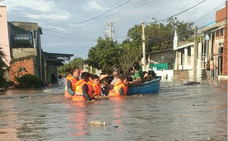 Lực lượng chức năng xã Liên Hương đưa người dân ở vùng ngập sâu về nơi an toàn.