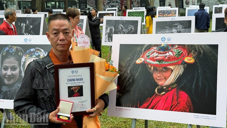 Tác giả Lê Khái Nhân (Thành phố Hồ Chí Minh) bên tác phẩm giành Huy chương Vàng thể loại Chân dung của mình.
