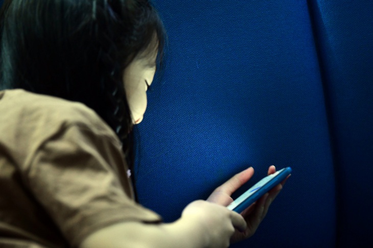 Điện thoại di động dễ cuốn hút trẻ đến quên ăn quên uống - Ảnh: QUANG ĐỊNH

