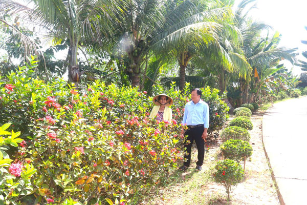 Cô Phạm Thị Đèo phấn khởi khi tự tay chăm sóc hoa góp phần làm đẹp cảnh quan địa phương.

