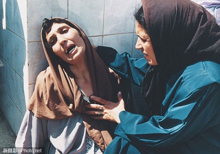 2003: Một người đàn ông Iraq vỗ về đứa con trai trong một trại giam tù nhân chiến tranh ở An Najaf.