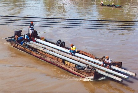 Vận chuyển vật tư thi công đường dây trung thế, đưa điện về vùng sâu phục vụ dân sinh. Ảnh: BÁ LÂM (TP Vĩnh Long)