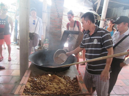 Anh Trương Văn Lợi đang cho lúa vào chảo rang