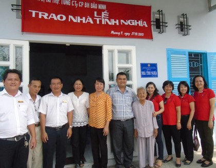 Bà Trần Ngọc Tốt (thứ 5 từ phải qua) vui mừng trước căn nhà mới khang trang.