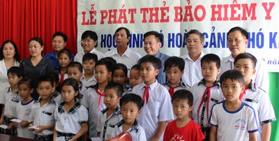 Các đơn vị trao thẻ BHYT cho học sinh tại Trường Tiểu học Phú Lộc (Tam Bình).