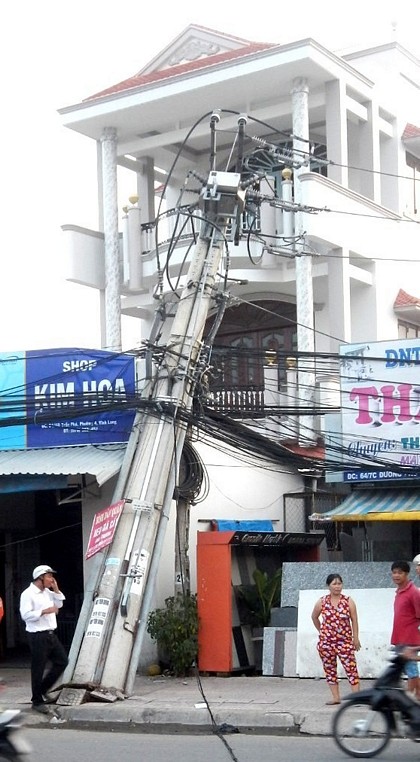 Trụ điện đôi ngả nghiêng tại vòng xoay cầu Ông Me có dấu hiệu bị “đứt chân” khỏi đế bê tông bảo vệ. Ảnh: MINH SƠN (CAVL)