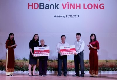 Ông Đỗ Hoàng Huynh- Chủ tịch UBMTTQVN tỉnh Vĩnh Long cùng bà Đào Thị Biểu đại diện nhận 2 căn nhà và 100 thẻ bảo hiểm y tế tượng trưng từ lãnh đạo Ngân hàng HD Bank. 