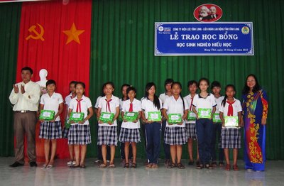 Bà Phạm Thị Lệ- Phó giám đốc Công ty Điện lực tỉnh và Hiệu trưởng trường Tân Long trao học bổng cho các em