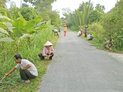 Vận động bà con cùng làm cỏ, phát quang làm sạch đẹp con đường.