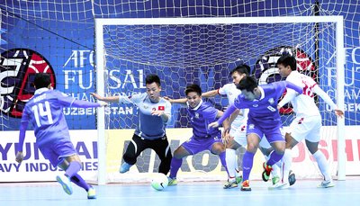 TM Văn Huy (VN) trước pha tấn công của các cầu thủ Thái Lan (áo xanh).