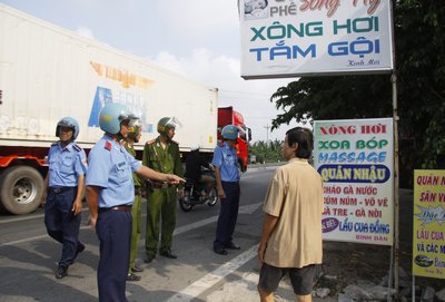 Tổ công tác liên ngành tuyên truyền, nhắc nhở chủ quán tự di dời bảng hiệu ra khỏi hành lang an toàn đường bộ.