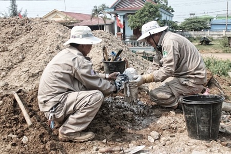 Nhân viên đội rà phá xử lý an toàn quả pháo trước khi đưa ra khỏi hiện trường