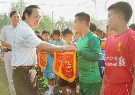Ông Ninh Duy Phương- Giám đốc Công ty Bảo Việt Vĩnh Long trao cờ lưu niệm cho các đội trong lễ khai mạc giải.