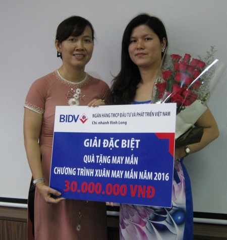 Bà Mai Thị Tầm- Phó Giám đốc BIDV Chi nhánh Vĩnh Long (trái) trao thưởng cho khách hàng trúng giải đặc biệt. 
