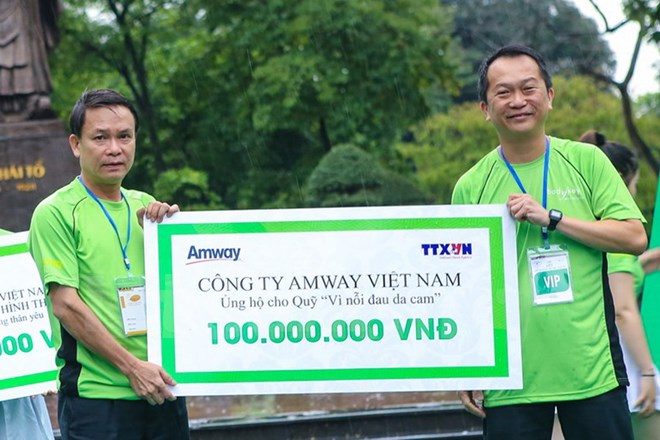 Tổng Giám đốc Thông tấn xã Việt Nam, Nguyễn Đức Lợi nhận số tiền 100 triệu đồng cho Quỹ da cam của TTXVN và 400 triệu đồng cho chương trình từ thiện hướng về miền Trung. (Ảnh: Minh Sơn/Vietnam+)