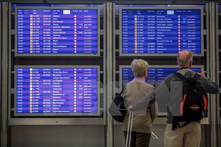 Hành khách xem bảng thông báo hủy các chuyến bay tại sân bay ở Frankfurt. (Nguồn: AFP/TTXVN)