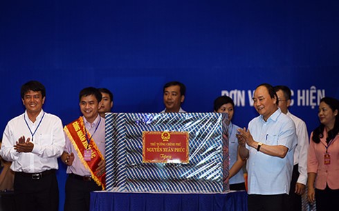 Thay mặt Chính phủ, Thủ tướng Nguyễn Xuân Phúc tặng quà cho đại diện công nhân tại các khu công nghiệp - Ảnh: Quang Hiếu