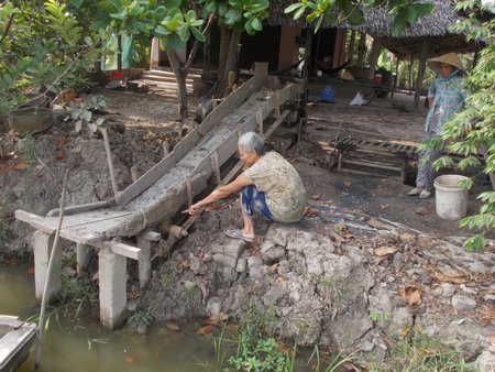 Bà Bùi Thị Bảy (mẹ anh Hoàng) chỉ tay về phía đầu băng tải cối gạch nơi xảy ra tai nạn.