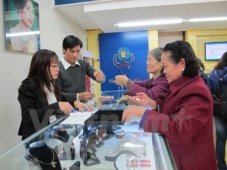Khách hàng đang giao dịch vàng miếng. (Ảnh: Đức Duy/Vietnam+)