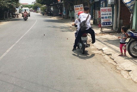 Trong khi đó, hình ảnh một học sinh không đội mũ bảo hiểm, vừa có hành vi đùa giỡn (cụ thể là nhảy từ trên yên xe xuống đất trong khi xe vẫn còn di chuyển) gây nguy hiểm cho bản thân và người đi đường. Phóng viên đã theo các em này đi từ đường Trần Đại Nghĩa đến đường Trần Phú (TP Vĩnh Long).