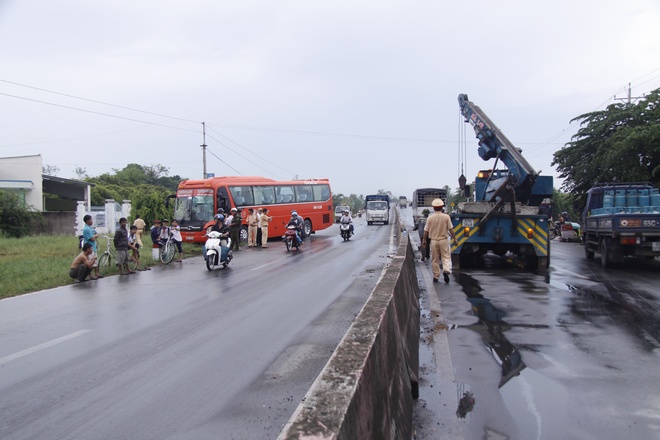 Xe cứu hộ đã đưa xe tải rời khỏi hiện trường đang lắp lại dải phân cách để tránh ách tắc giao thông. Xe khách còn đang ở hiện trường.   