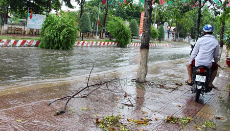  Xe máy chạy lên vỉa hè để tránh nước.