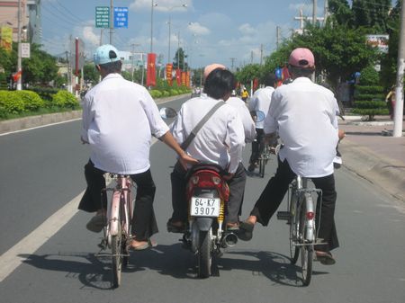 Các em học sinh lái xe máy thường chạy hàng hai, hàng ba và còn đèo, kéo mất ATGT.